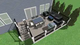 A modern backyard deck with black furniture, including sofas and a dining table, next to a grey house and green lawn.