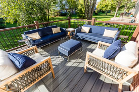 outdoor deck featuring modern patio furniture with deep blue cushions