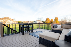 A spacious outdoor deck with patio furniture with grey cushions