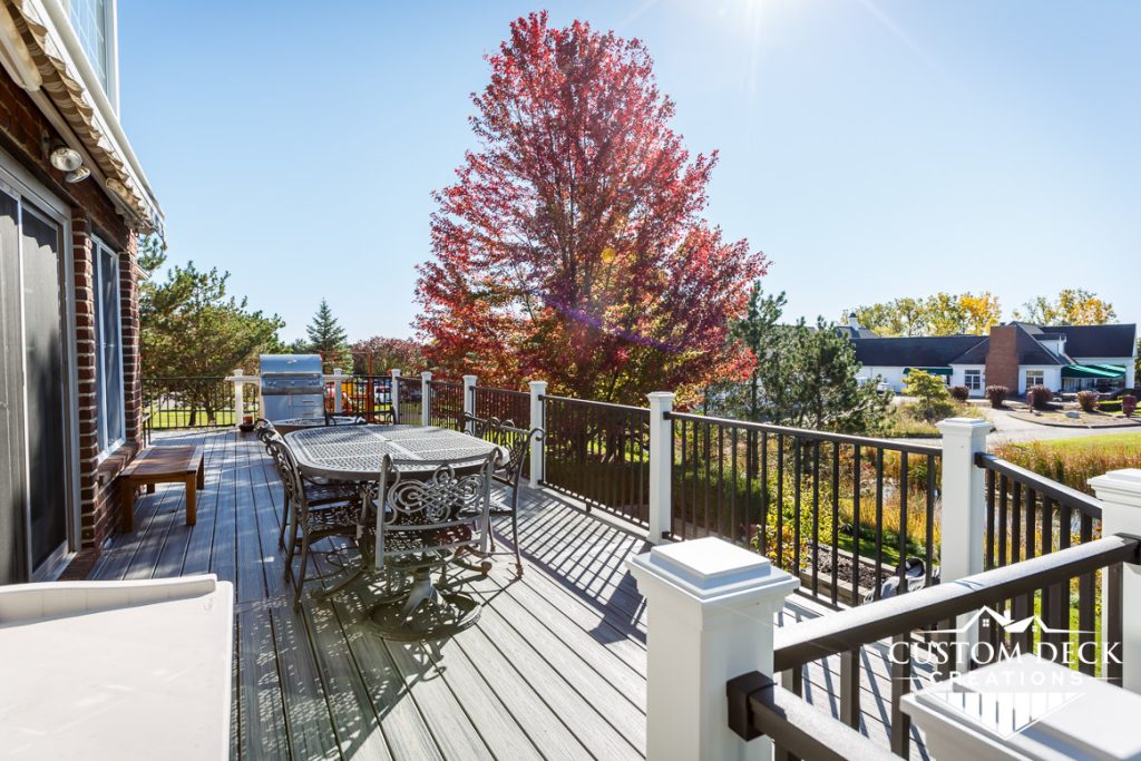 Trex deck in fall with furniture and a red tree